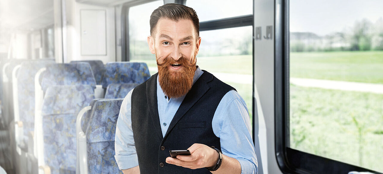 Mann mit Vollbart und Handy in der Hand